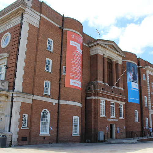 Large victorian style red brick building with roman features