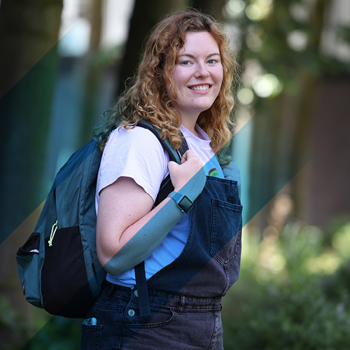 Person with shoulder length hair holding a backpack