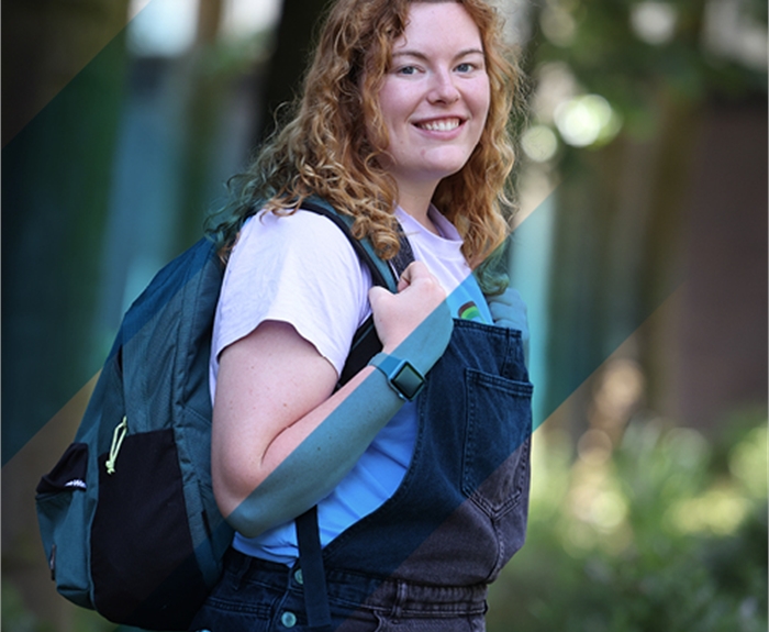 Person with shoulder length hair holding a backpack